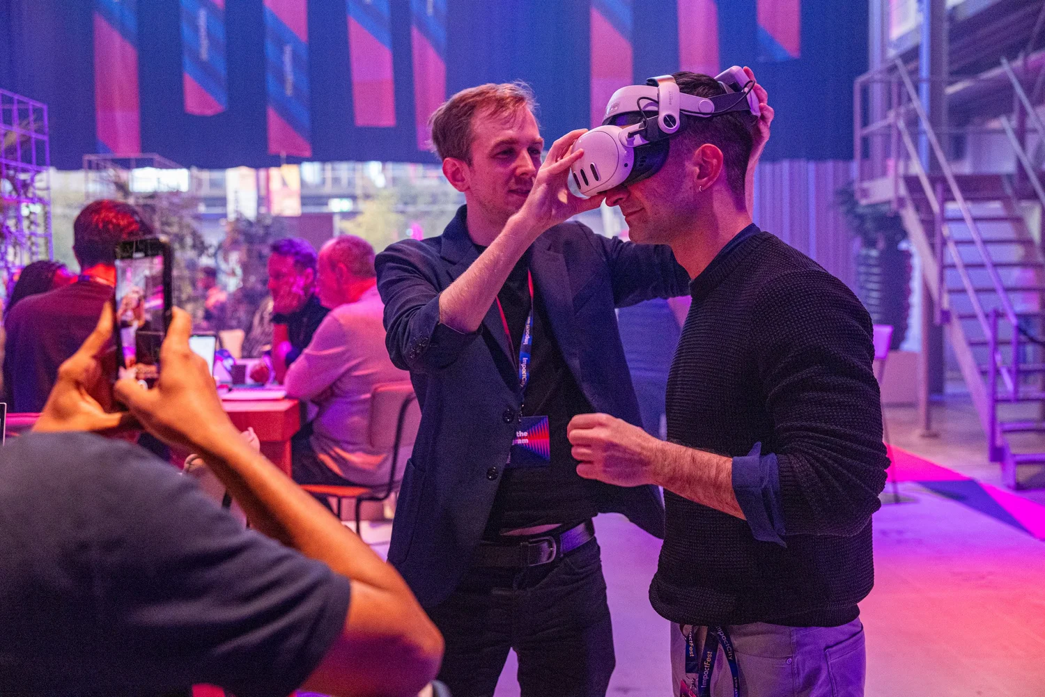 A trainer helping a participant put on a VR headset at an event