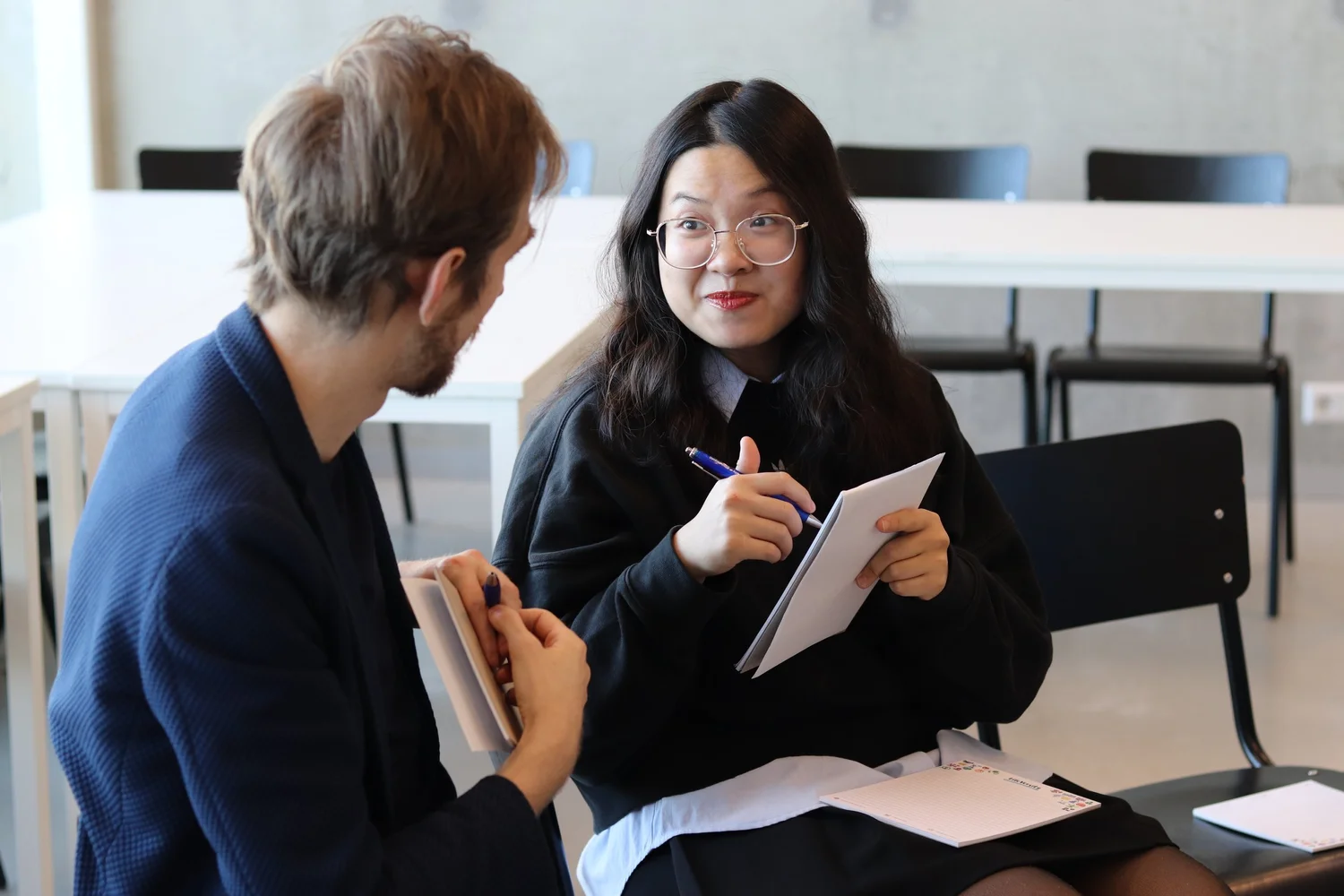 Two participants giving each other feedback with notes