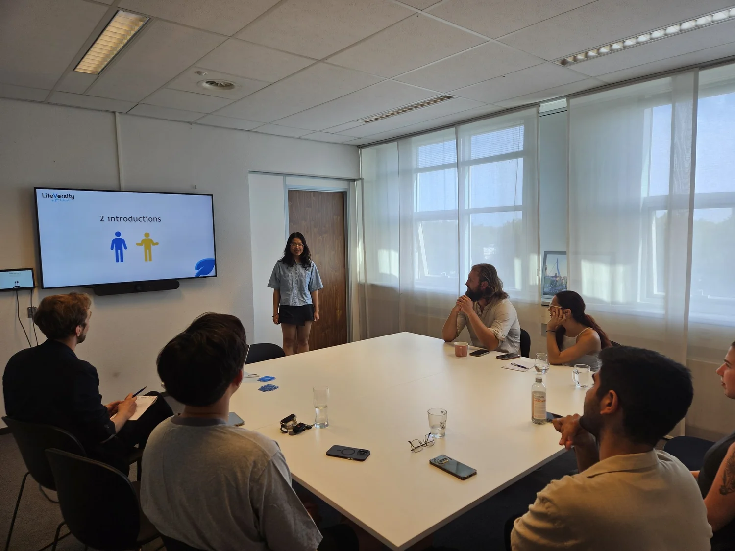 A participant presenting to a small group around a table
