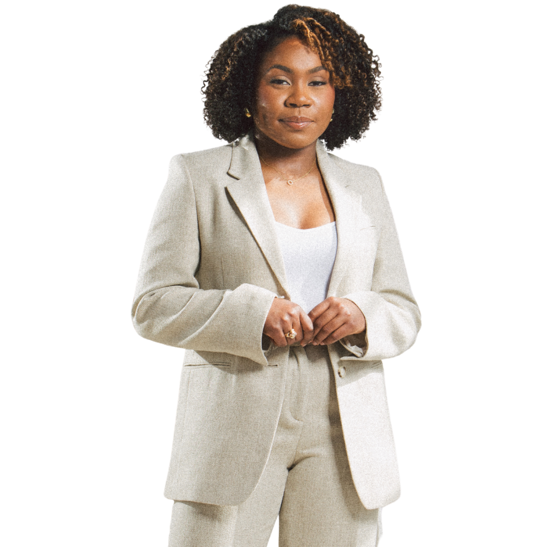 Jessicah Pierre in a beige pantsuit and white shirt standing with her hands clasped.