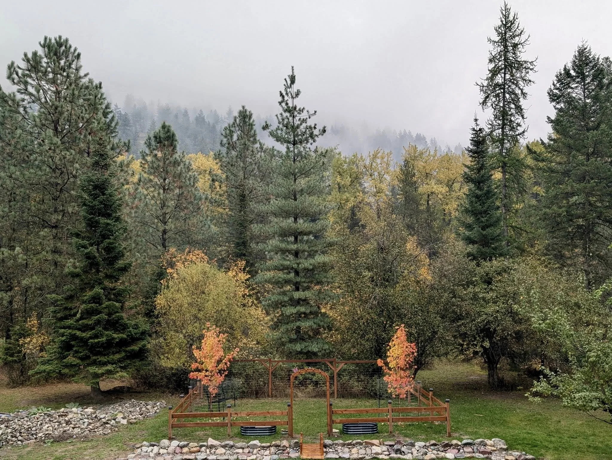 Custom outdoor property improvement with wood fencing, garden arbor, and mountain landscape in Western Montana.