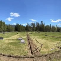 Property maintenance and sprinkler installation site work with trenching across a large grassy area.