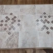 Interior finish detail with tile countertop pattern and wood flooring in a kitchen remodel.