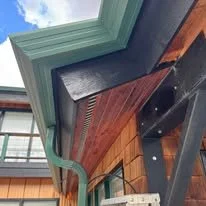 Close-up of exterior trim, soffit, gutter, and roofline finish work on a residential property.
