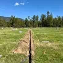 Sprinkler installation and trenching work across a maintained lawn area for property site improvements.