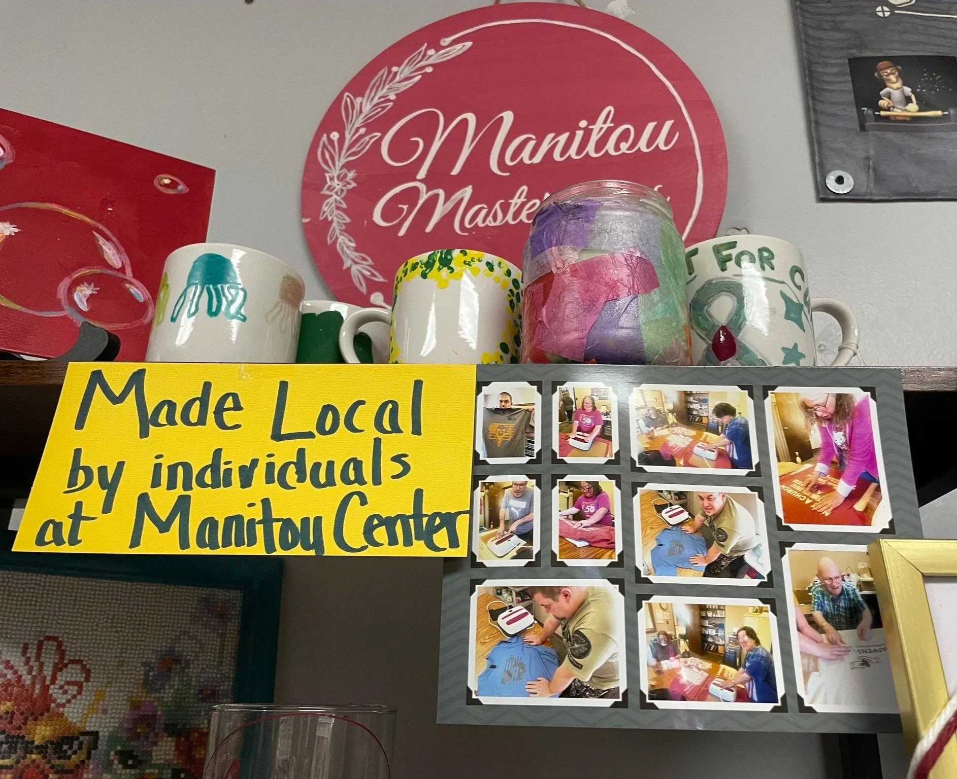 Display of handmade mugs and a collage of people making crafts, with a yellow sign that reads 'Made Local by individuals at Manitou Center'.