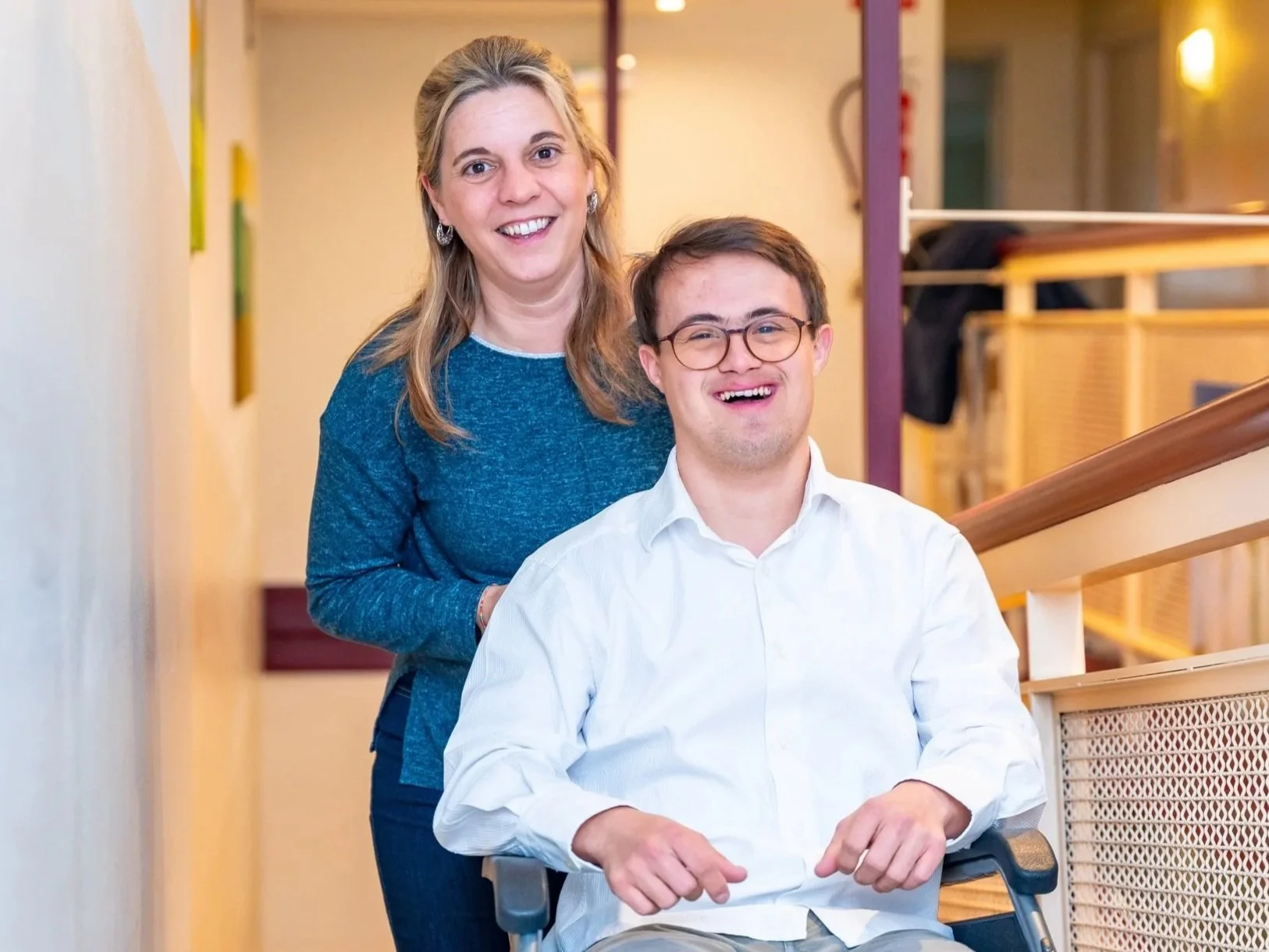 Individual and support staff smiling together in a residential setting, representing the housing stability and independence protected through Marshall-Starke Development Center.