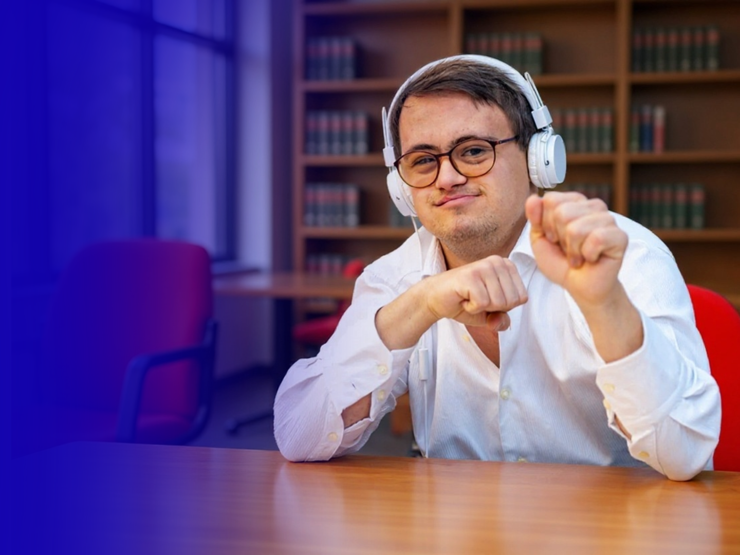 Adult wearing headphones and smiling at a desk, representing independence and support services provided through Marshall-Starke Development Center.