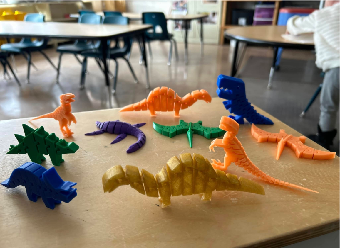 Colorful dinosaur-shaped toys on a table in a classroom.