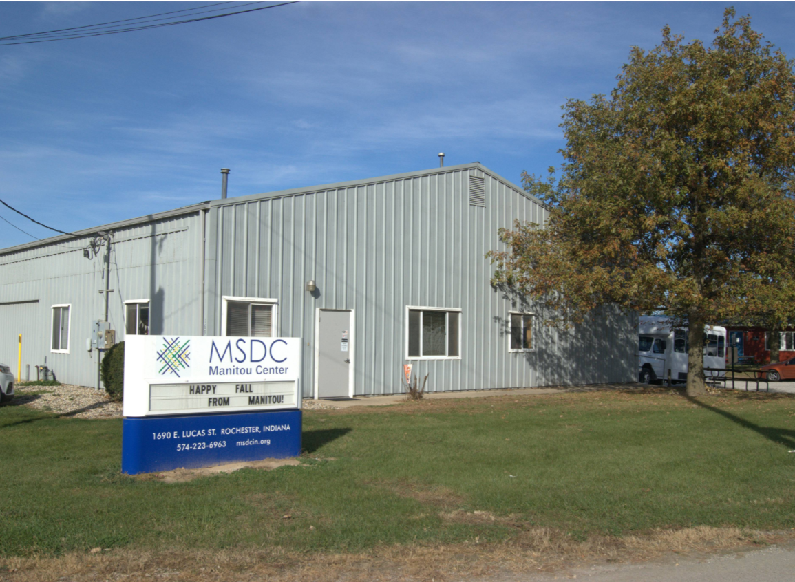 Photo of the Manitou Center building with a sign in front that reads 'HAPPY FALL FROM MANITOU' at 1690 E. LUCAS ST., ROCHESTER, INDIANA.