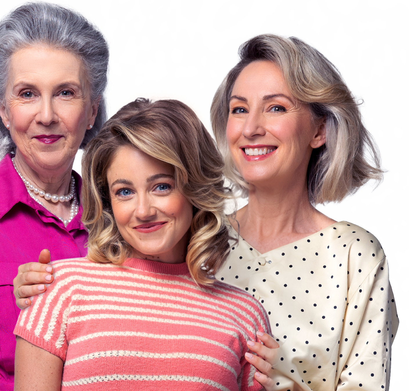 Three women, a senior woman on the left, a middle-aged woman on the right, and a young woman in the middle, smiling and posing together against a plain background.