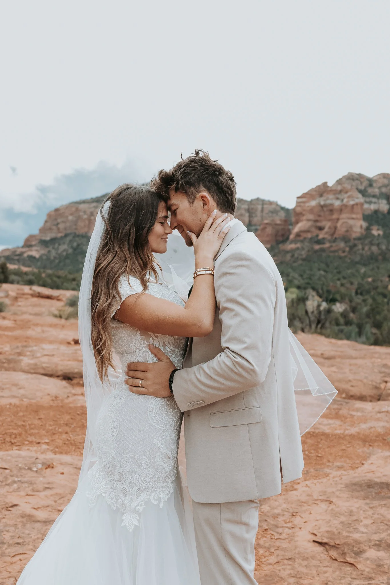 Romantic Sedona Red rock elopement moment with bride and groom holding each other.