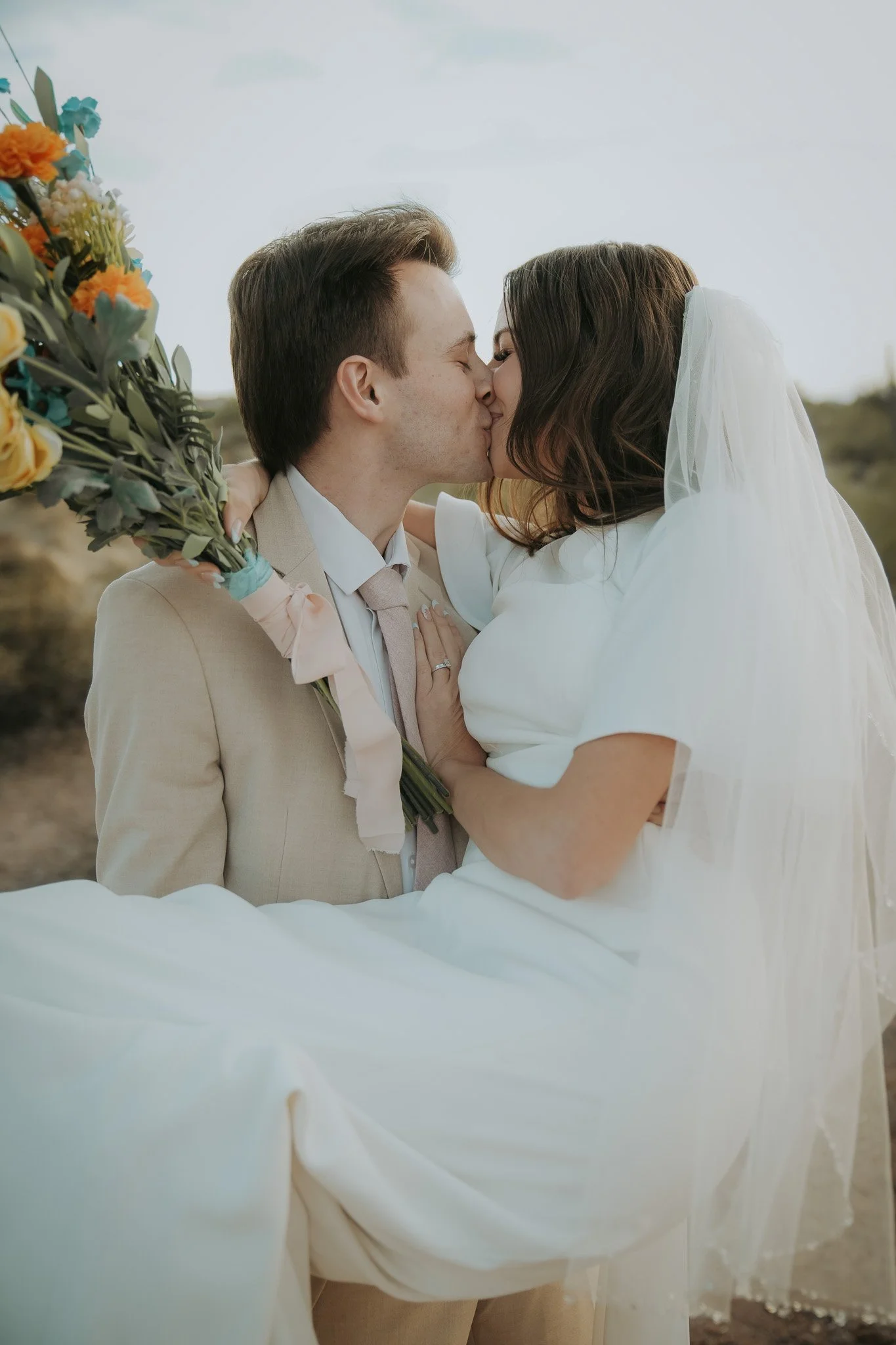 Sedona Elopement photo of couple kissing with desert backdrop and intimate, golden-hour light.