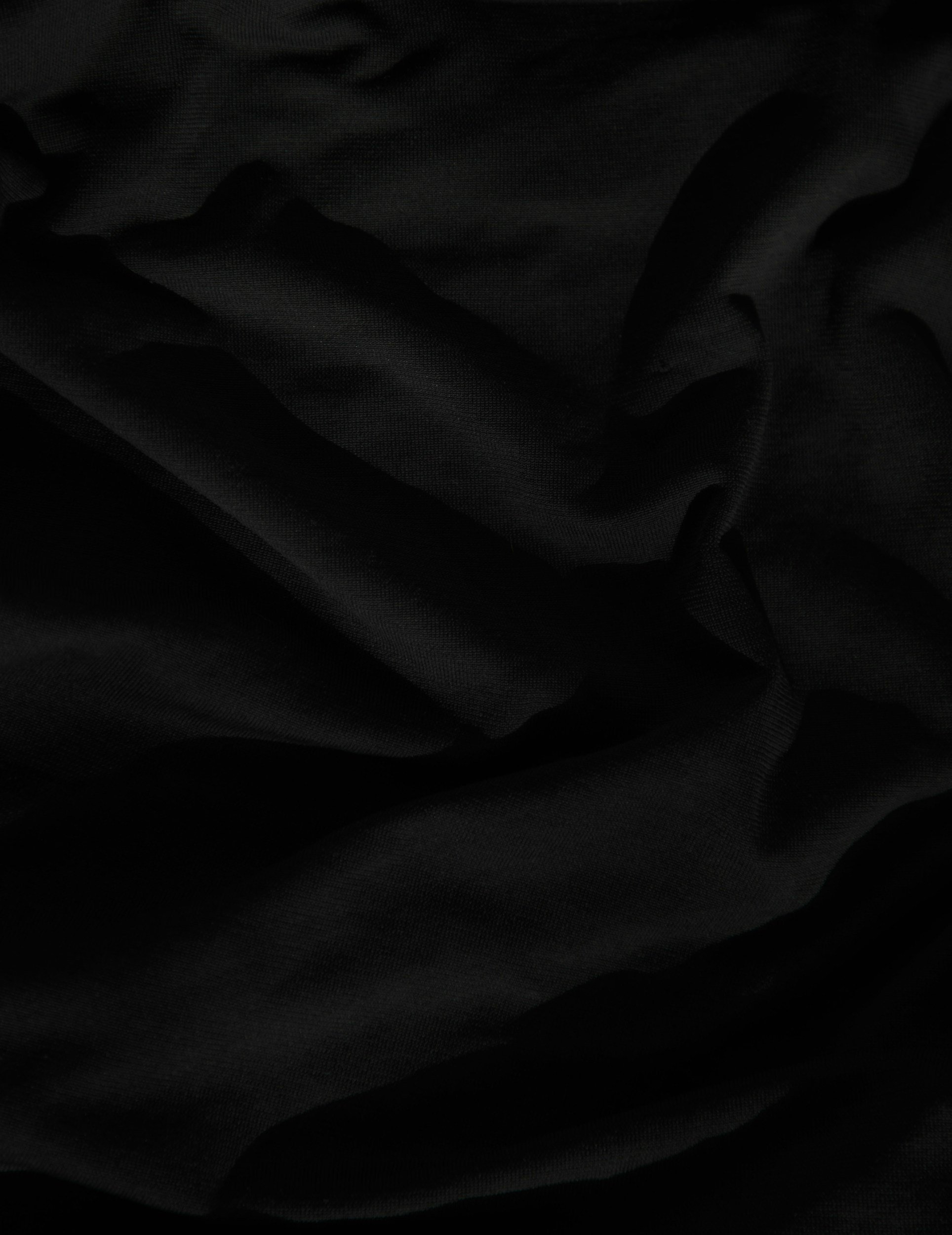 Close-up of black fabric with soft folds and smooth texture.