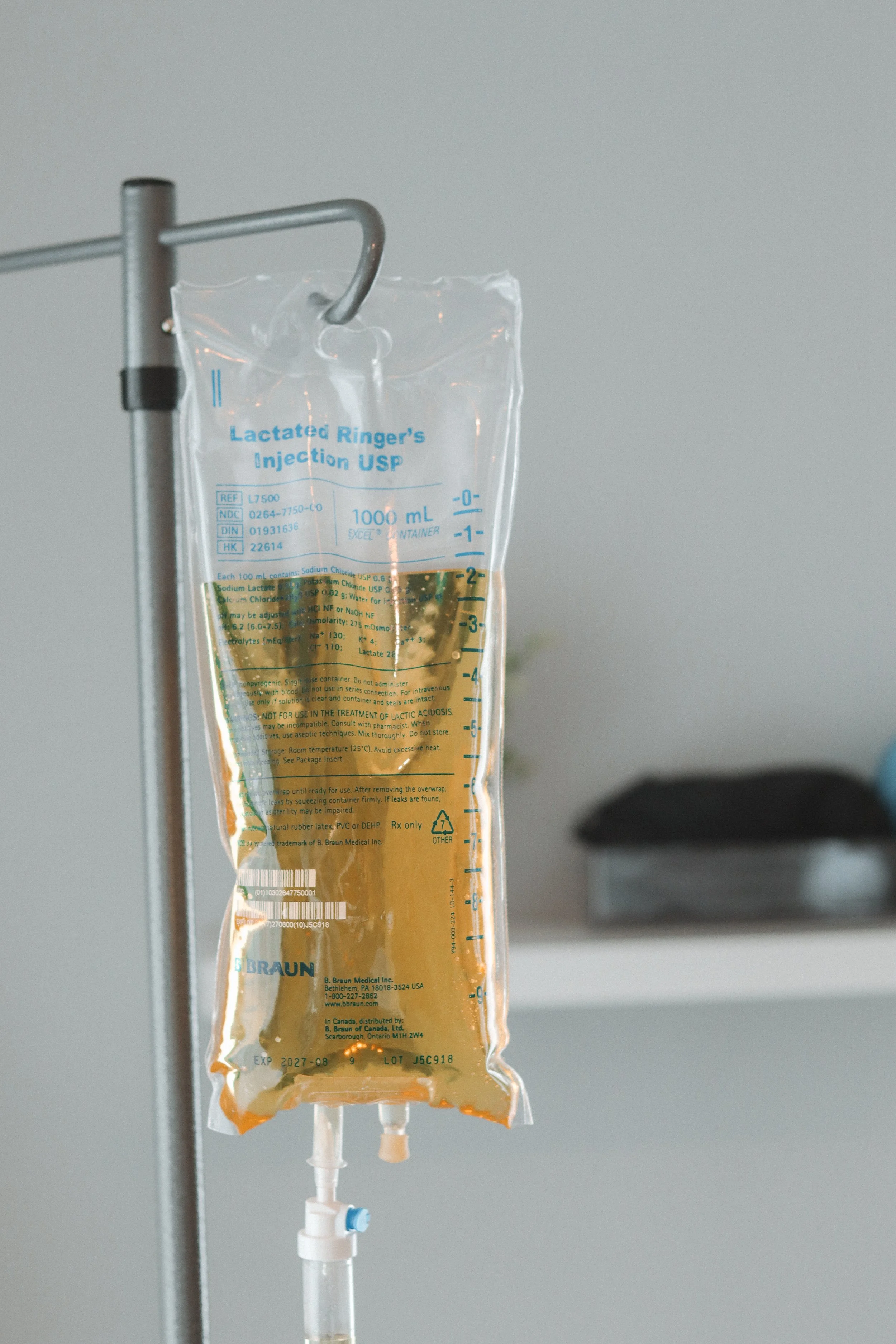IV bag containing yellowish liquid hanging from a metal pole