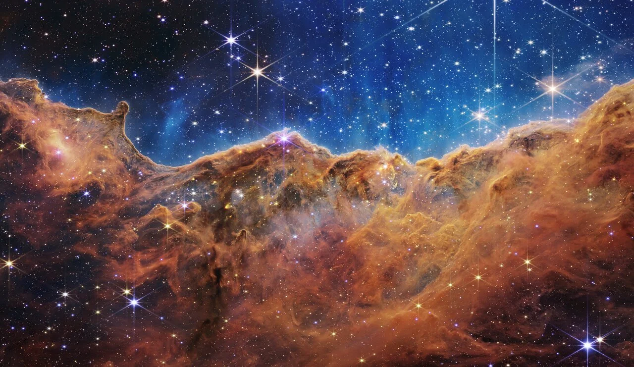 A celestial photograph from the James Webb Space Telescope of the Carina Nebula.