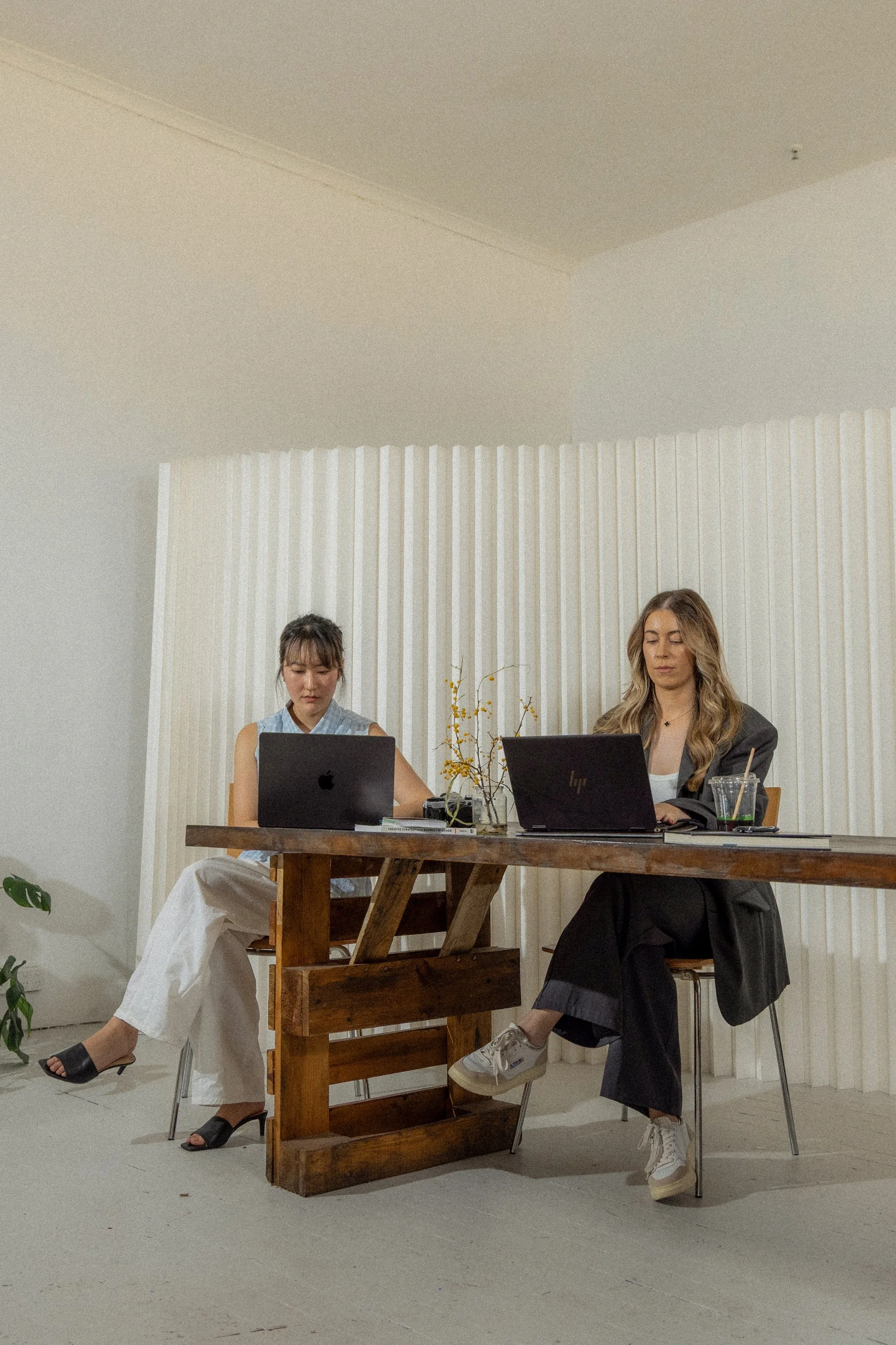 Two marketing employees working at desk with laptops