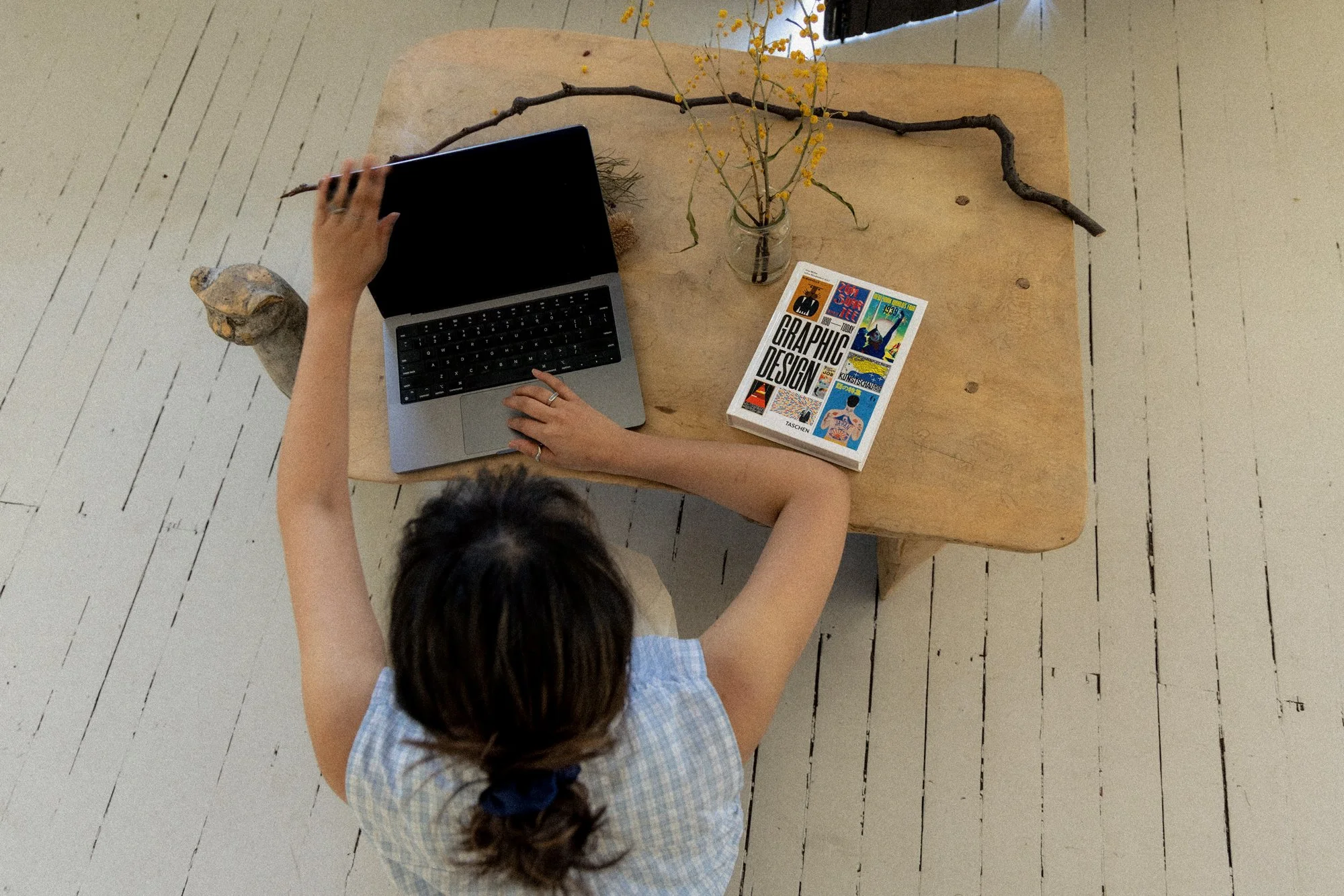Tuesday Creatives employee with laptop and design book