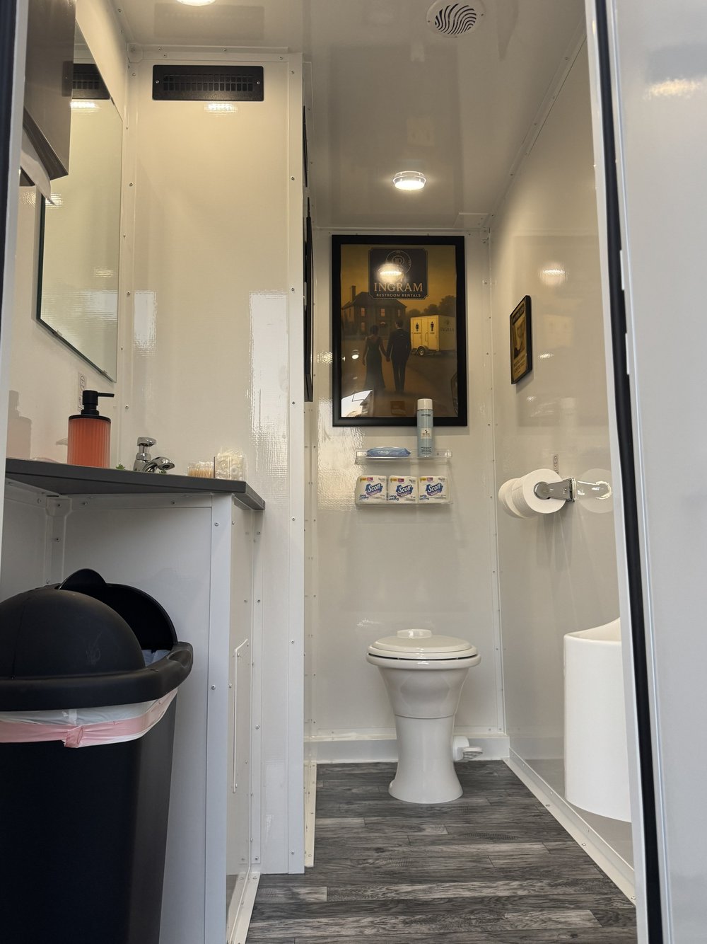 Lado de hombres de un tráiler de baños de Ingram con lavamanos y urinario