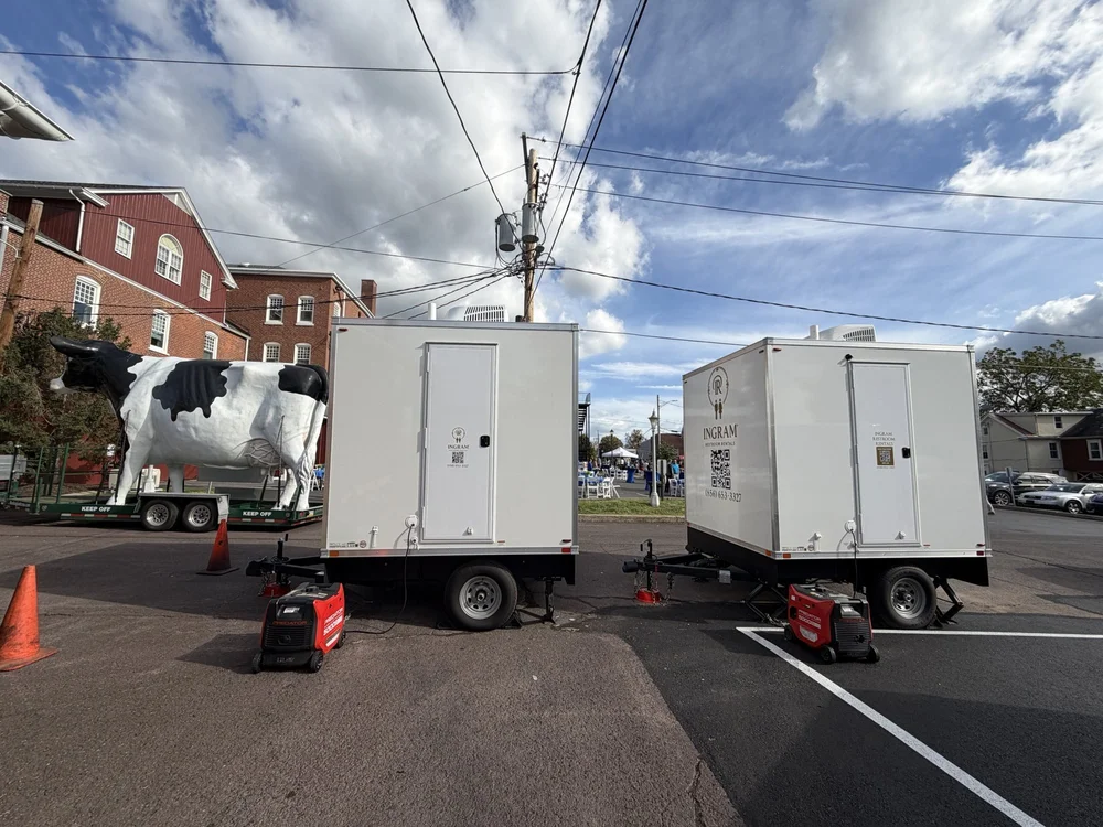Two Ingram luxury restroom trailers set up at a community event on a town street