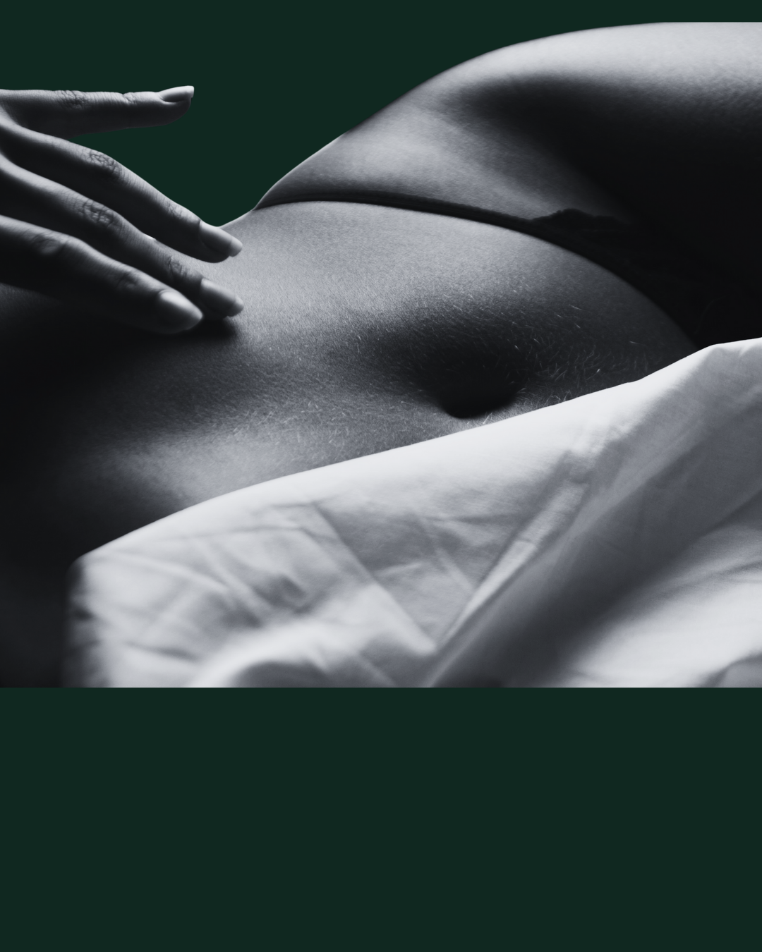 Close-up of a person's torso laying on a bed, with a hand resting on the chest, in black and white.