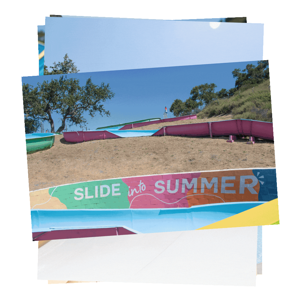 Rotating images of colorful water slides at a summer outdoor park with trees and blue sky in background, and a sign that reads "Slide into Summer" at Mustang Waterpark.