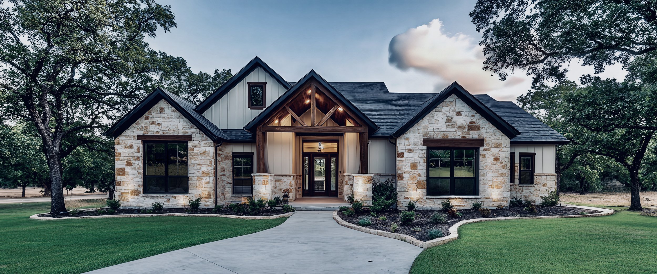 A modern house with stone and siding exterior, gabled roof, surrounded by green lawn, and trees in the background.