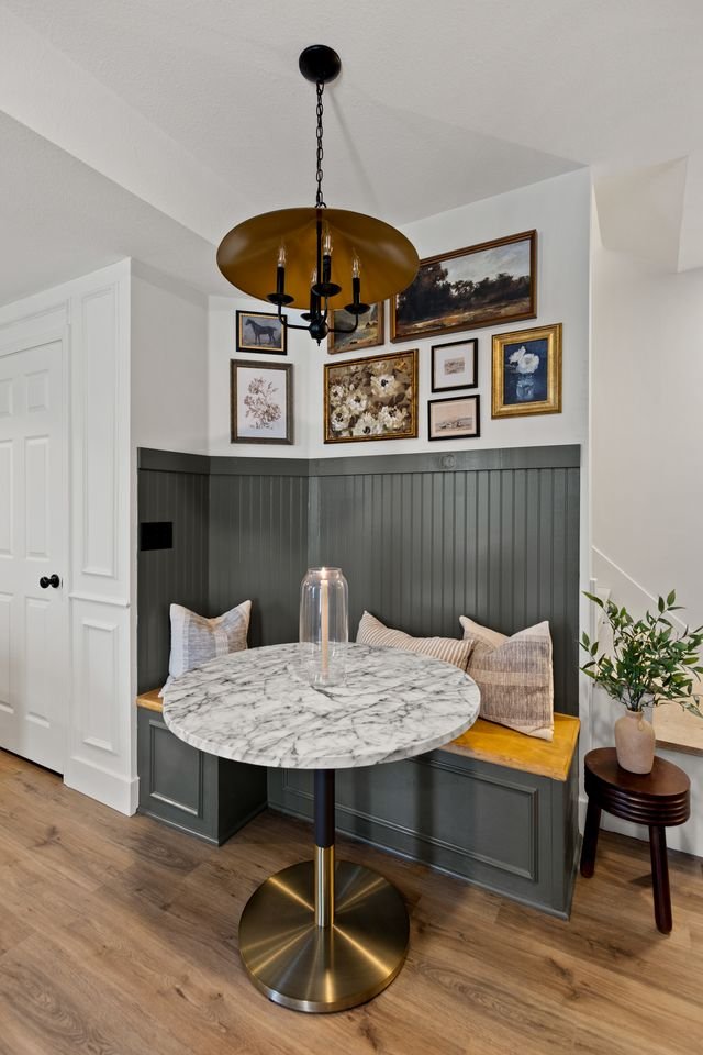 cute breakfast nook with small marble table and an accent wall of pictures