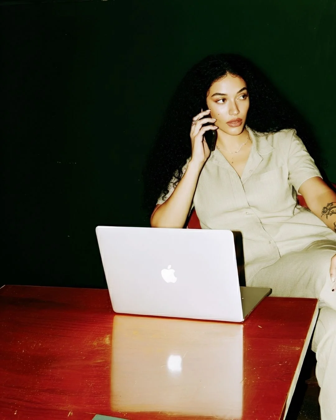 Woman on the phone behind a Mac Book