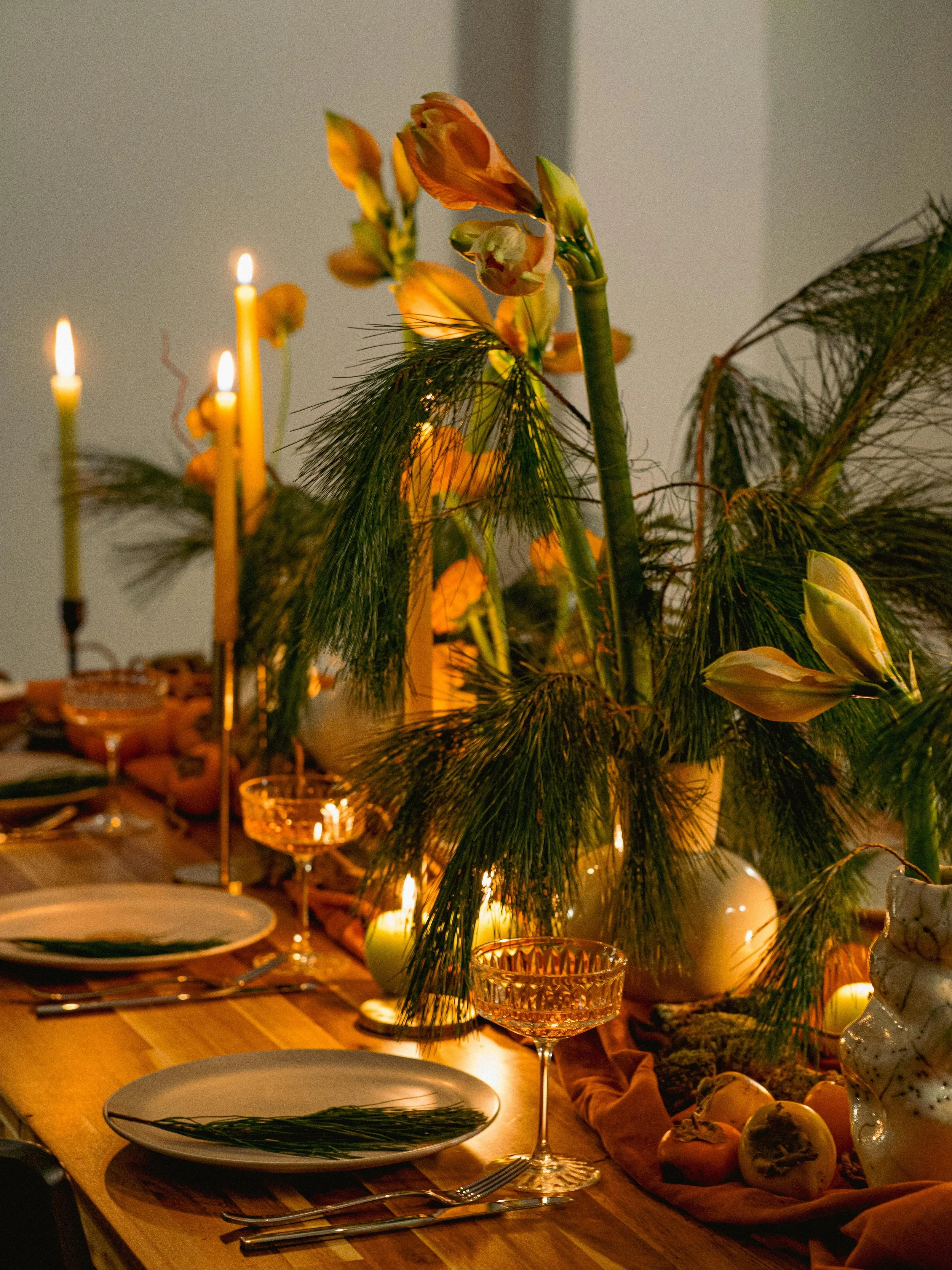 Dining table set with champagne glasses, lit candles, and floral centerpieces