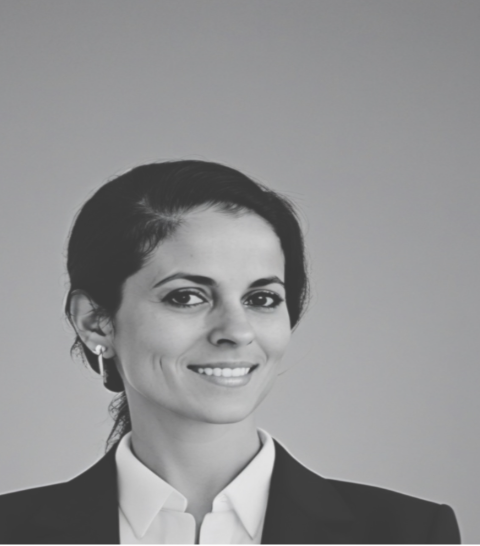 Black and white portrait of a smiling woman with short dark hair, wearing a suit jacket and white shirt.
