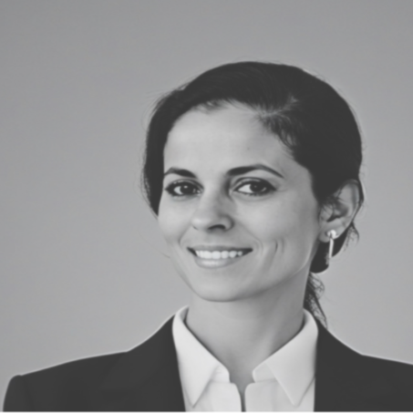 Black and white portrait of a woman smiling, wearing a suit and white shirt.