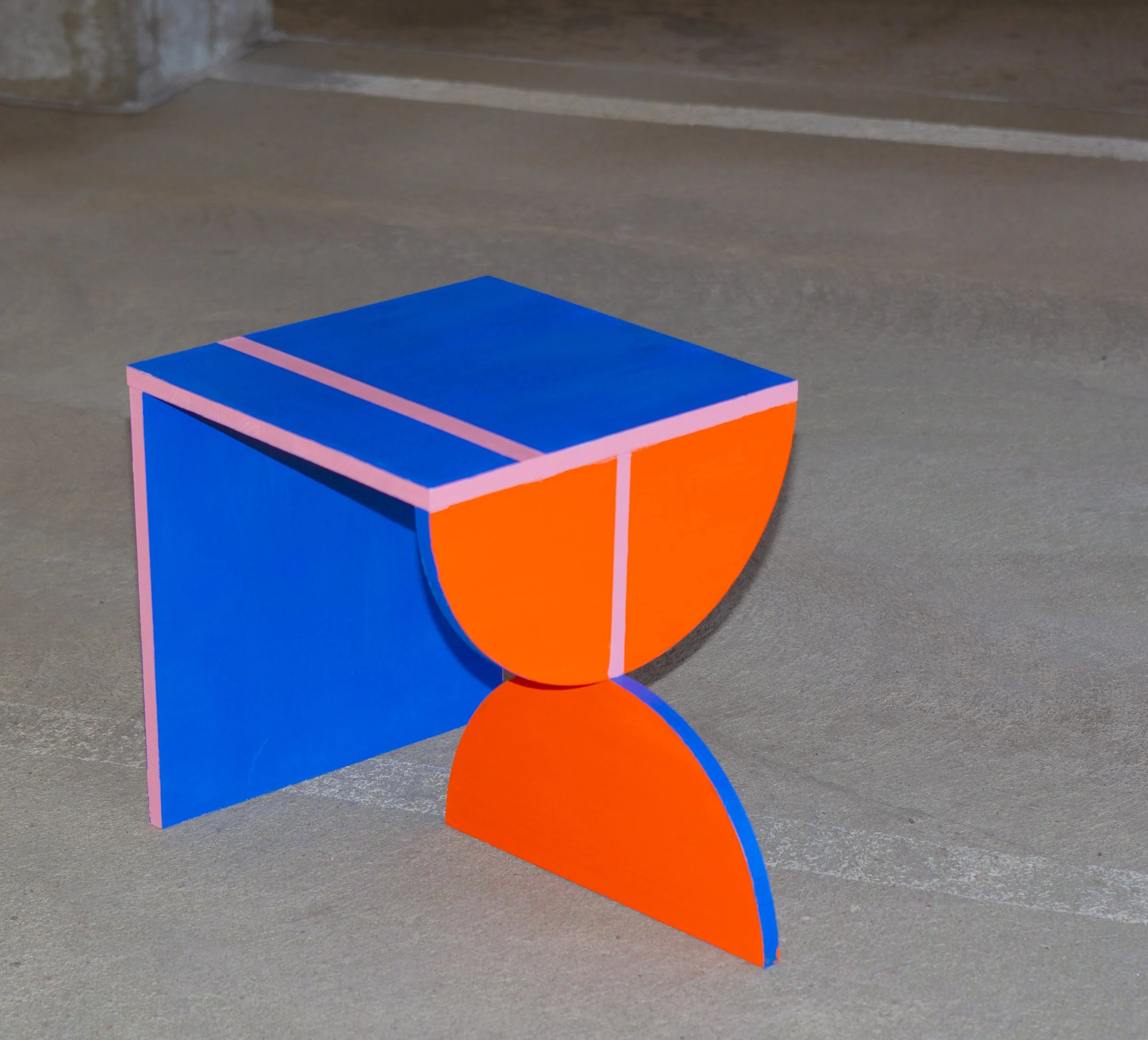 Värikäs abstrakti veistos, jossa on geometrisia muotoja ja päällekkäisiä kerroksia, pääasiassa sinistä ja oranssia.