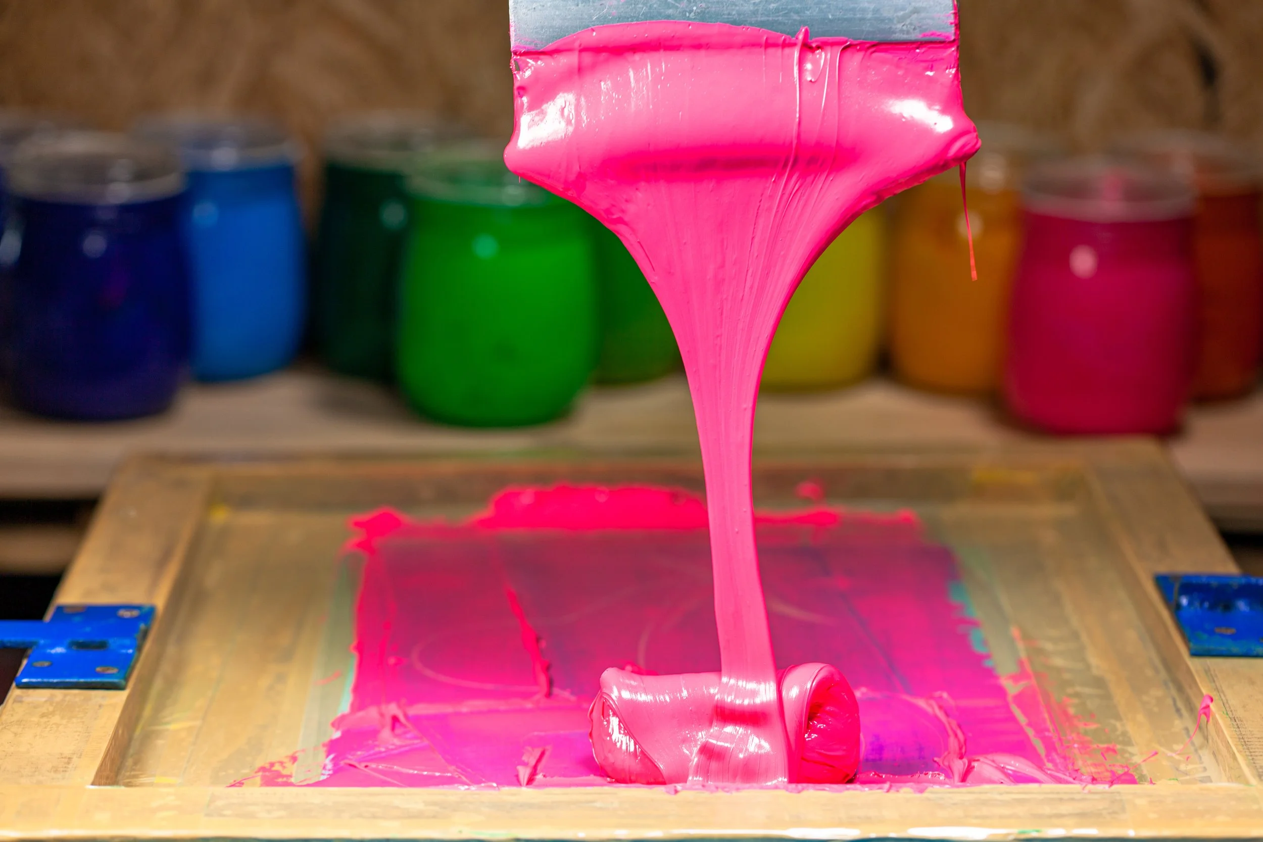Pouring pink ink on a silkscreen