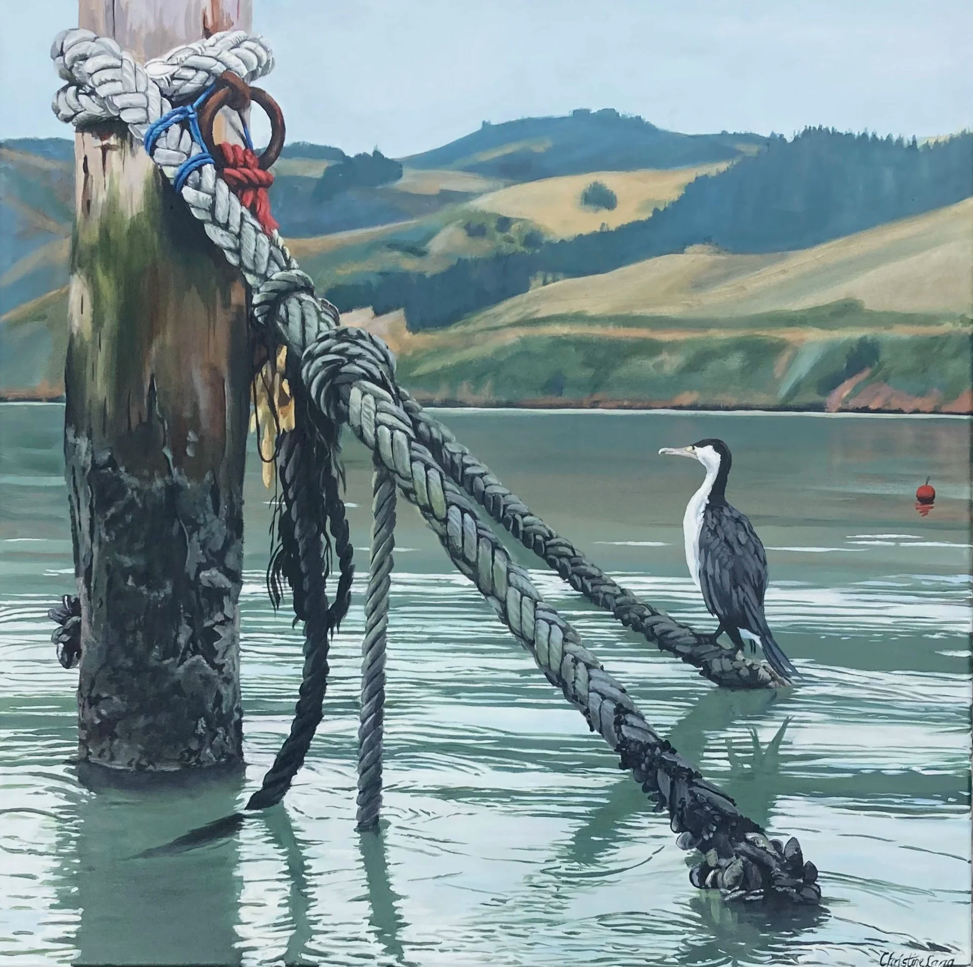 A painted scene of a seagull perched on a fallen, weathered wooden post with thick ropes tied around it by a lake. In the background, green rolling hills under a cloudy sky.