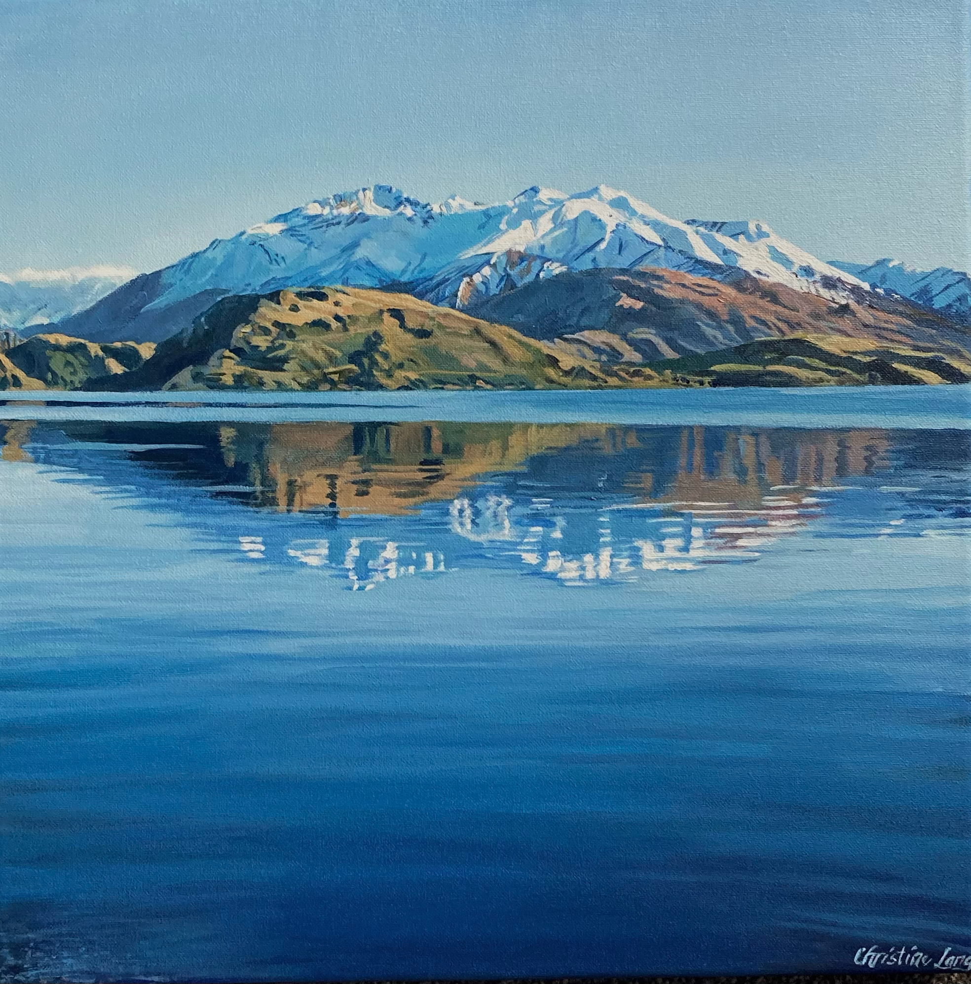 A painting of snow-capped mountains reflected in a calm lake with green hills in the foreground.