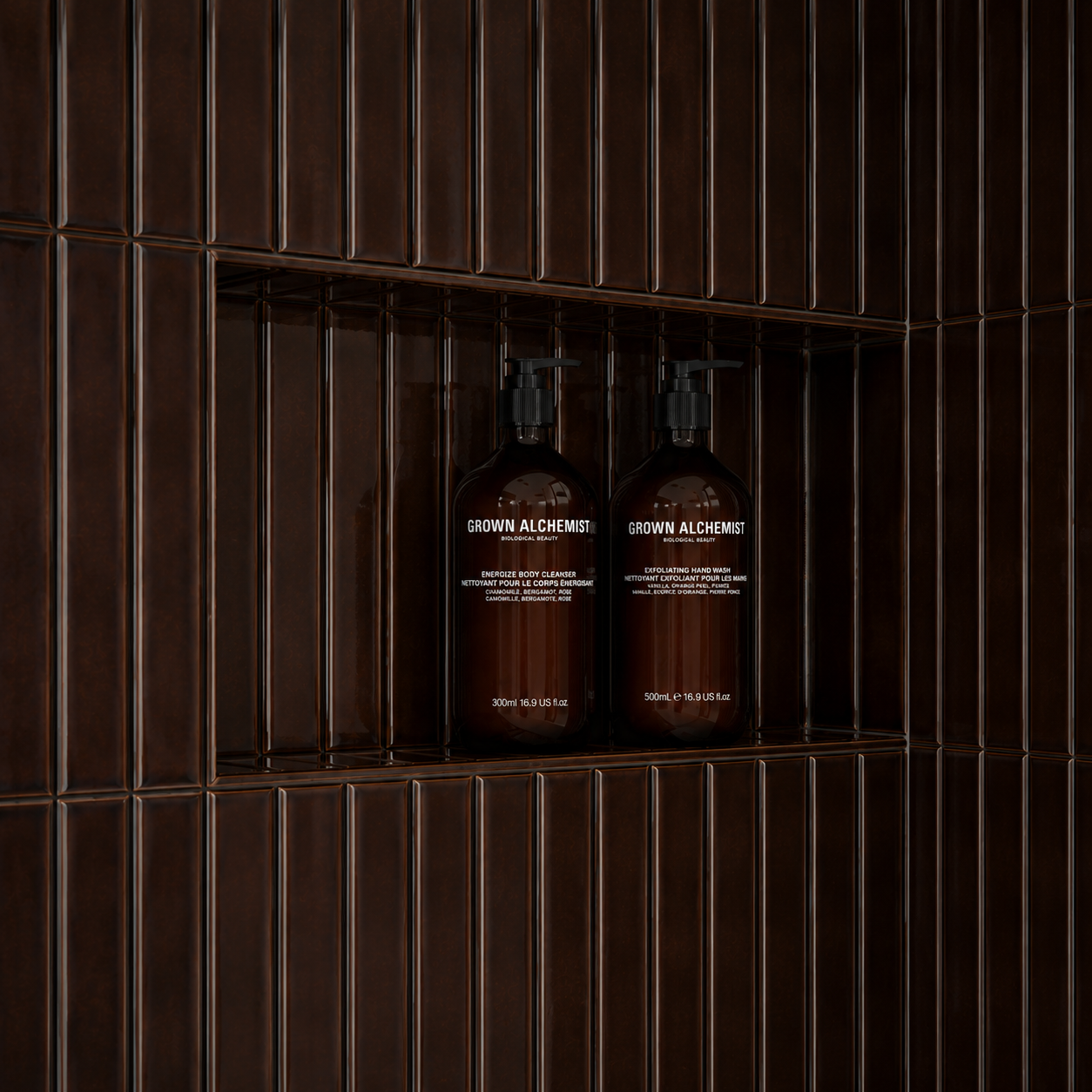 Two brown bottles of Grown Alchemist skincare products on a wood shelf with metal bars.