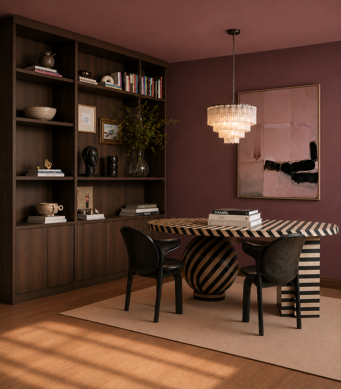 Contemporary dining room with a black and white striped round table, two black chairs, a large wooden bookshelf with decorative objects and books, a modern chandelier, and an abstract painting on a mauve wall.