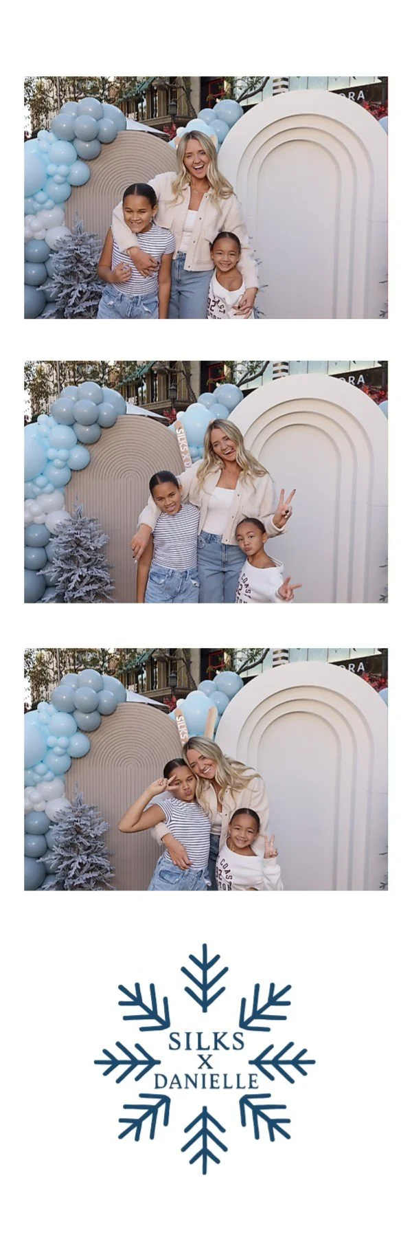 A woman and two young girls pose in front of a decorative backdrop with balloons and snow-covered trees. In the first image, they stand smiling, in the second, they make peace signs, and in the third, they strike playful poses. The backdrop features 