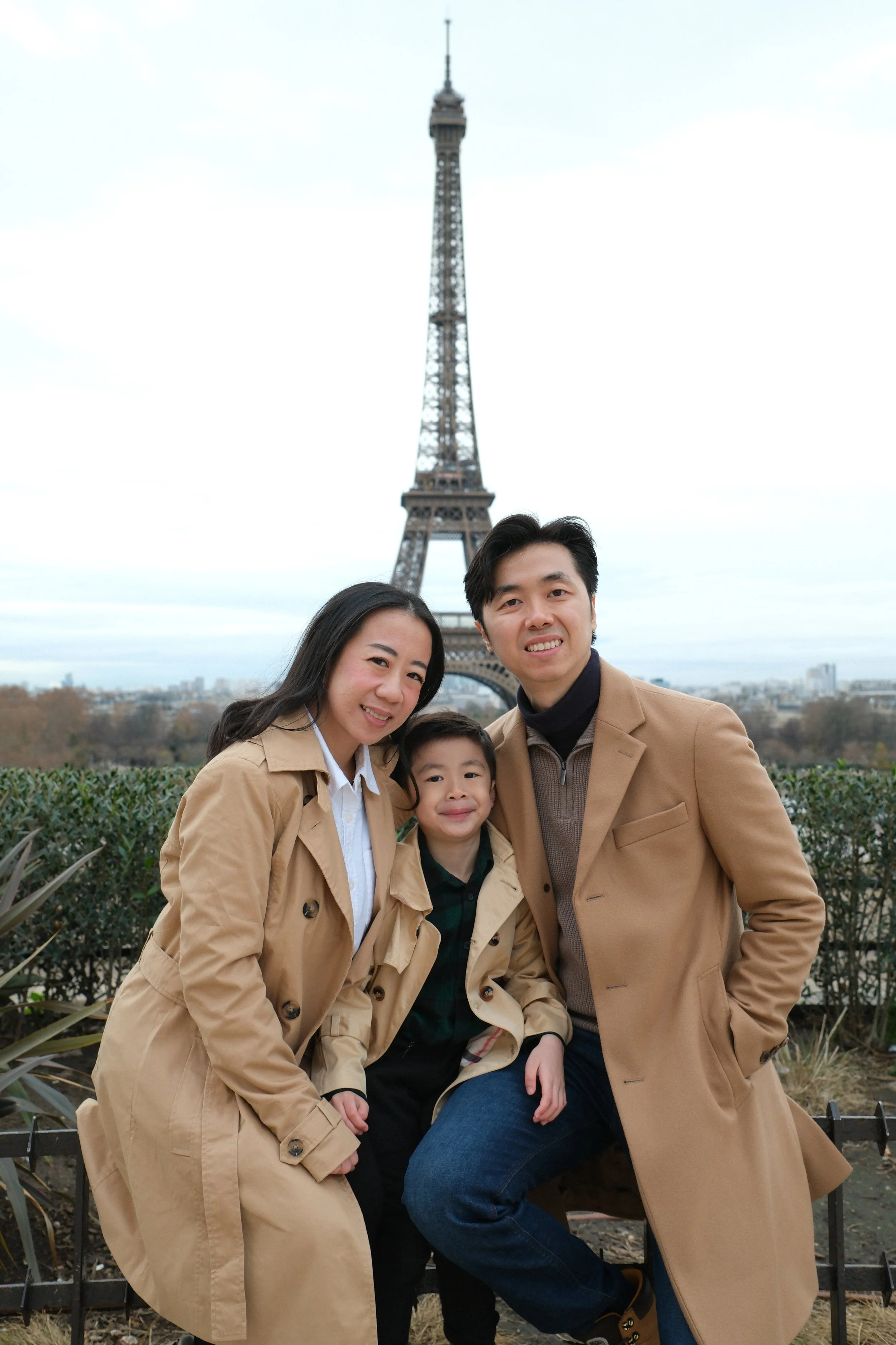 Family of three in front of the Eiffel Tower in Paris, France.
