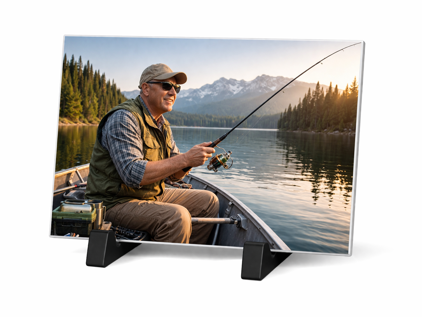 A man in a boat fishing on a calm lake at sunset, surrounded by mountains and pine trees.