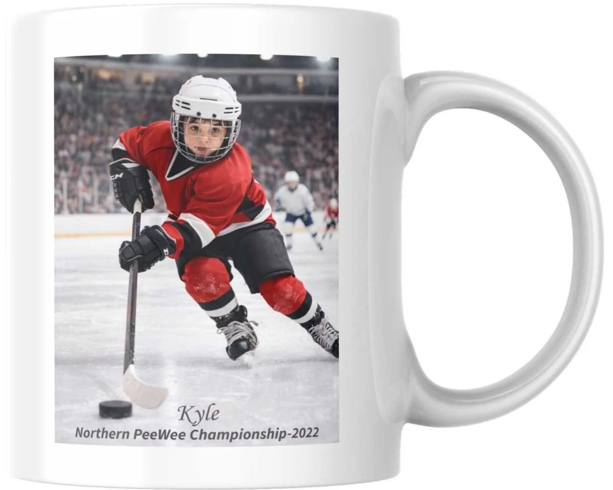 White ceramic mug with a printed photo of a young hockey player in red and black uniform and helmet, playing ice hockey, with an arena and other players in the background. Text on the mug reads "Kyle Northern PeeWee Championship-2022."