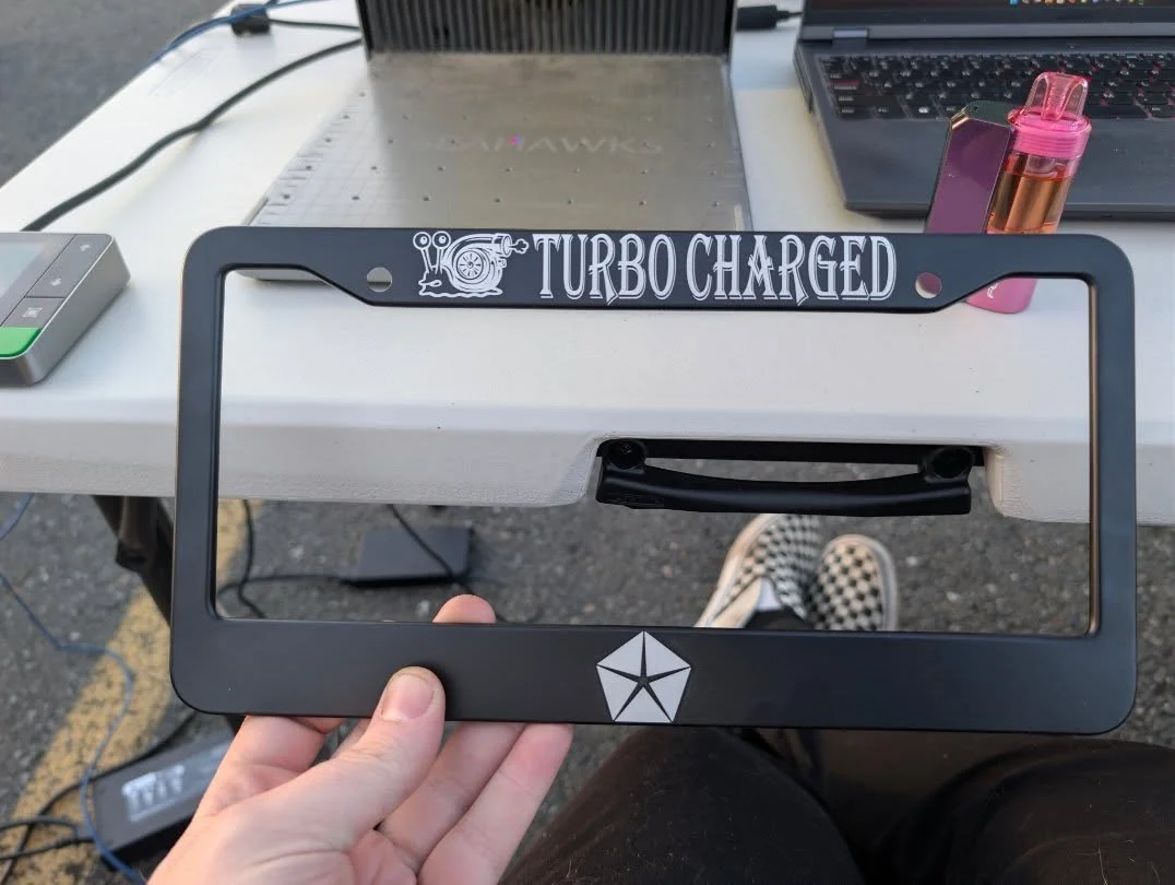 Friday Arlington Walmart meet: @falcon_3spd grabbed a custom plate frame and a metal‑card engraving of his badass wagon &mdash; a keepsake built to outlive the car and the legend.