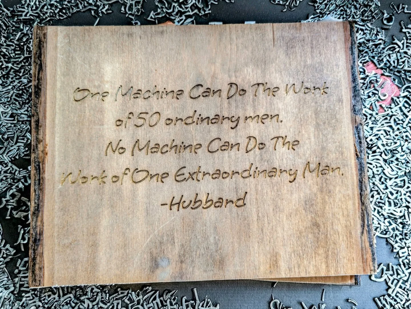 Engraved this live‑edge plaque for a machinist who proves it every day &mdash; one extraordinary human outworks anything a machine could dream of. Wood, steel, grit, and a quote that hits harder the longer you stare at it.