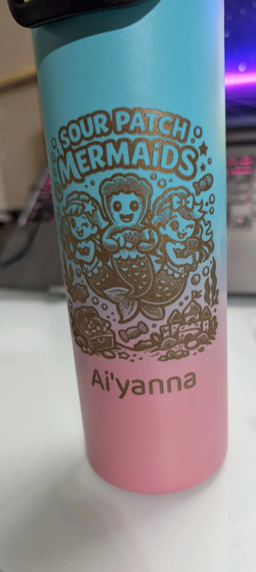 Blue-to-pink gradient tumbler engraved with the Sour Patch Mermaids team design and the name Ai'yanna