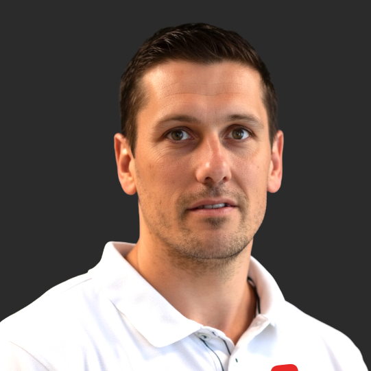 CEO Mike wearing a white collared shirt standing against a dark background.