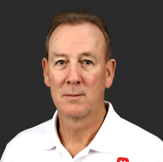 Peter wearing a white polo shirt, against a dark gray background.