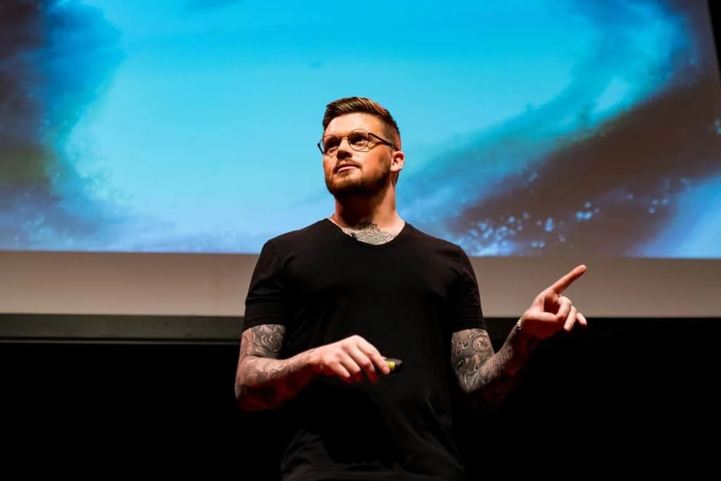Lewis Raymond Taylor, who is psychopath, life coach and PhD holder, shares his story in a lecture hall.