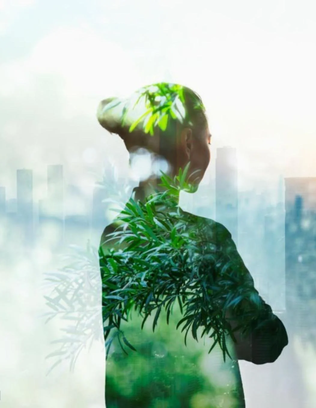 A silhouette of a woman with hair styled in an updo, overlaid with green leaves and foliage, standing against a blurred cityscape background.