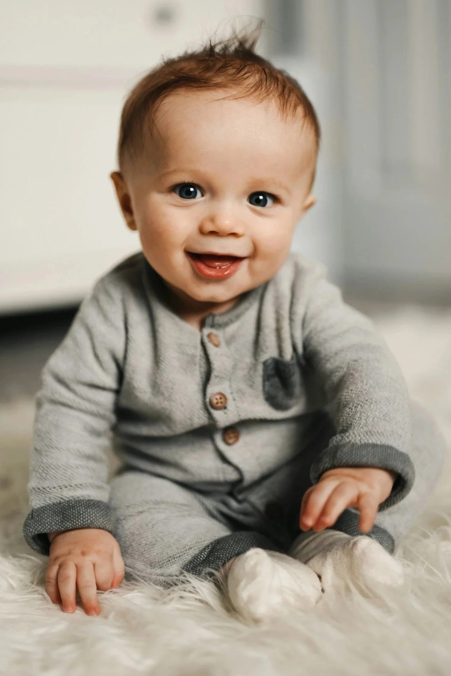 Baby sitting in the best style and material clothing that optimizes gross motor development